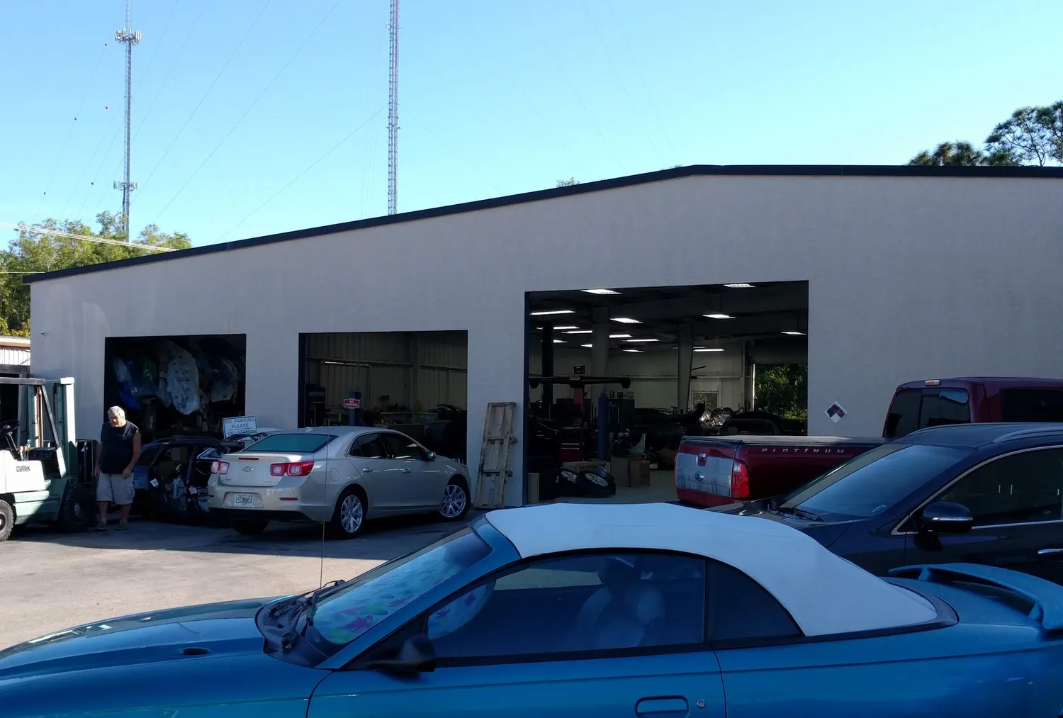North Collier Collision's repair bays with cars in the lot