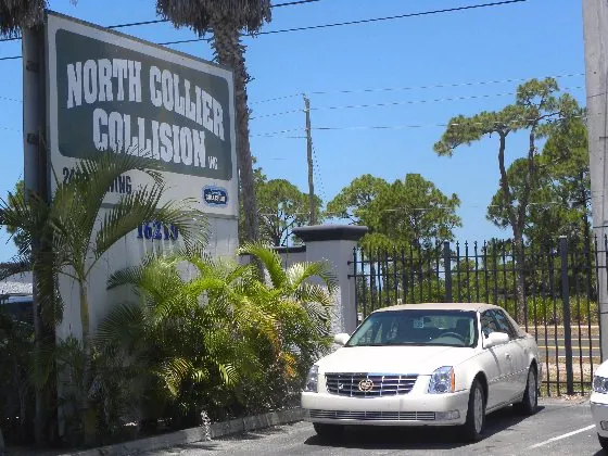 The North Collier Collision sign and lot in daylight